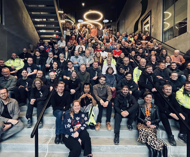 Polytech team group photo on office staircase — careers, company culture, and life